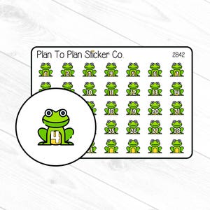 May include: A sheet of frog-themed stickers with numbers 1-28. Each sticker features a green frog with a white outline and a number. The stickers are arranged in rows and columns, with a larger frog sticker in a circle.