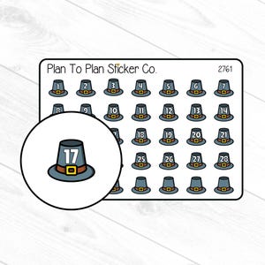 May include: A sheet of stickers featuring small, cartoon pilgrim hats, each with a number from 1 to 28. The hats are blue with brown brims and gold buckles. A magnified view of hat number 17 is in a circle.