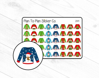 May include: A sheet of 36 Christmas sweater stickers featuring various designs, including a snowman, gingerbread man, Christmas tree, and ornaments. The stickers are printed on white paper and have a glossy finish. The sheet is labeled "Plan To Plan Sticker Co." and "2411".