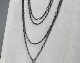 Antique Edwardian long watch chain necklace with bezel set clear stones and charm or fob clip in black or japanned metal