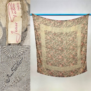 Op de afbeelding: Een vintage bloemenprint sjaal met een witte rand. De sjaal is gemaakt van een zachte, lichte stof en heeft een delicate, vrouwelijke uitstraling. De sjaal is in goede staat en heeft een klassiek, tijdloos ontwerp.