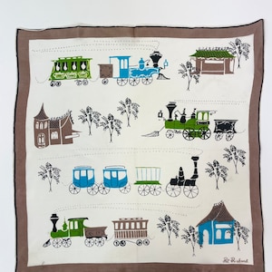 May include: A vintage white fabric with a brown border featuring a repeating pattern of green, blue, and brown trains, houses, and trees. The fabric is signed "Pat Richards".