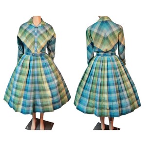 May include: A long-sleeved dress featuring a blue, green, and yellow plaid pattern. The garment includes a collared neckline, a button-down front, a fitted waist with a matching belt, and a full, pleated skirt that falls below the knee.