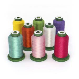 May include: A collection of eight spools of thread in various colors, including yellow, green, orange, white, pink, teal, purple, and red. Each spool is cylindrical with a green base and top, ideal for sewing and crafting projects.