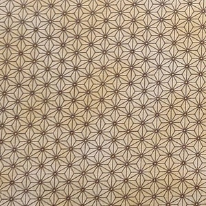 May include: A beige fabric with a repeating pattern of brown geometric stars. The pattern is a traditional Japanese design.