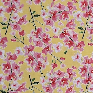 May include: A yellow fabric with a pink floral pattern. The flowers are stylized and have a delicate, watercolor-like appearance.