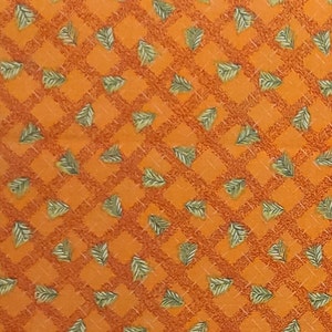 May include: Orange fabric with a checkered pattern and green leaf designs.
