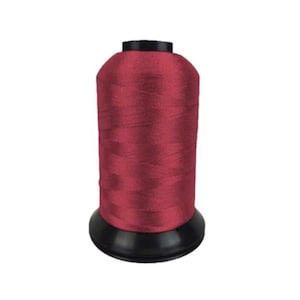 May include: A spool of burgundy thread. The thread is tightly wound on a black plastic base. The top of the spool is also black. The thread has a slight sheen, suggesting a smooth texture. Ideal for sewing and embroidery projects.