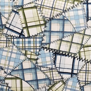 May include: A patchwork fabric with a blue and green plaid pattern. The fabric is sewn together in a random pattern with a decorative stitch around the edges of each piece.