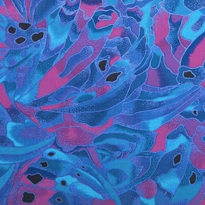 May include: Abstract fabric pattern in shades of blue, teal, and magenta. The design features flowing, organic shapes with a speckled texture and dark, irregular voids, creating a dynamic and colorful visual.