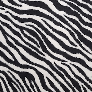 May include: Black and white zebra print fabric with a wavy pattern.