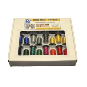 May include: A box of RNK Micro Thread, featuring a variety of colorful spools. The box has a clear window showcasing the thread colors, including blue, silver, gold, and red. The box has the text "RNK Micro Thread" and "New from RNK Distributing".