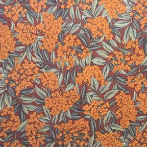 May include: A seamless fabric pattern featuring a repeating design of orange berries and green leaves on a dark red background.
