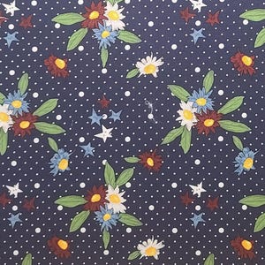 May include: A navy blue fabric with a repeating pattern of white polka dots, white and blue flowers, and red and white stars.