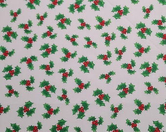 May include: White fabric with a repeating pattern of green holly leaves with red berries.
