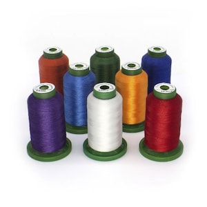 May include: A collection of eight spools of thread in various colors, including red, orange, yellow, green, blue, and purple. Each spool is cylindrical with a green base and a white label on top. The threads are tightly wound, showcasing a range of vibrant hues.