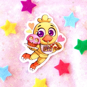 May include: A yellow cartoon chicken character with purple eyes is holding a pink cupcake and a slice of pizza. The character is wearing a bib that says "Let's Eat!!!".