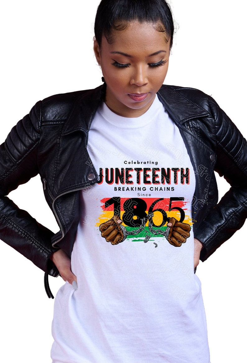 May include: White t-shirt with a black graphic design that says "Celebrating Juneteenth Breaking Chains Since 1865". The graphic features a red, yellow, and green striped background with two black hands in handcuffs.