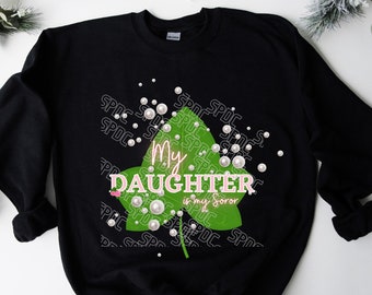 Può includere: Felpa nera con un design a foglia verde e il testo "My Daughter is my Soror" in rosa. Il design è circondato da perle bianche.