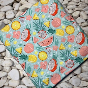 May include: A folded fabric with a tropical fruit pattern. The design features dragon fruit, watermelon, pineapple, and peaches in shades of red, yellow, and pink, set against a light blue background with floral accents.