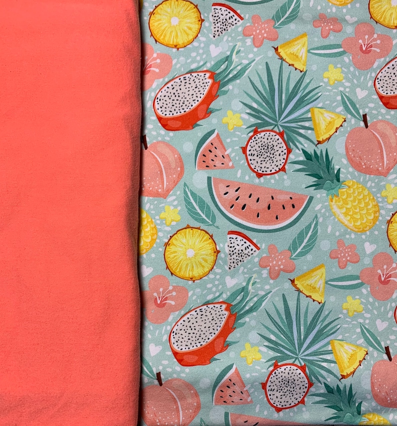 May include: Coral fabric next to a patterned fabric featuring tropical fruits like dragon fruit, watermelon, pineapple, and peaches. The background is a light teal with small white hearts and floral accents.