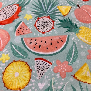 May include: A light teal fabric with a tropical fruit pattern. The design includes watermelon slices, dragon fruit, pineapple, and peach illustrations, along with green leaves and pink flowers. White hearts and dots fill the background.