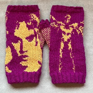 May include: A pair of fingerless gloves knitted in a vibrant magenta and golden yellow yarn. The left glove features a detailed portrait of a face, while the right glove displays a full-body silhouette of a person with arms outstretched.