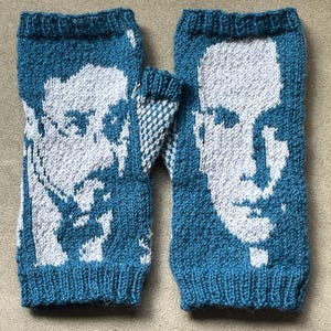 May include: A pair of blue knitted fingerless gloves with a white knitted design of a face on each glove.