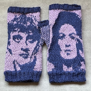 May include: A pair of fingerless gloves knitted with a two-tone pattern in dark blue and light purple. The design features a detailed portrait of a person on each glove, with ribbed cuffs at the top and bottom edges and a thumb opening on the side.