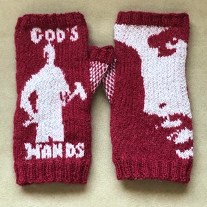 May include: A pair of red knitted fingerless gloves with white knit designs. One glove features a silhouette of a person holding an axe with the text "God's Hands". The other glove features a silhouette of a person's face.