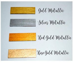 Puede incluir: Cuatro muestras met&aacute;licas en oro, plata, oro rojo y oro rosa. Cada muestra es una peque&ntilde;a pieza rectangular de metal.