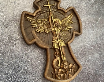 May include: A wooden cross with a gold-painted image of the Archangel Michael, holding a spear and standing on a dragon. The cross is inscribed with the words "Archangel Michael" and the shield reads "QUIS UT DEUS".