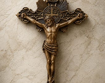 May include: A bronze-toned wall crucifix featuring a detailed figure of Jesus on the cross. The top of the cross displays the letters INRI above a circular medallion with the inscription PAX VOBIS. The cross has ornate, decorative ends.