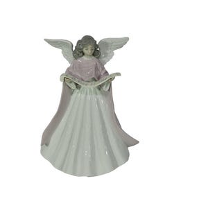 May include: A ceramic angel figurine with outstretched wings, wearing a pink shawl and a long, white dress. The angel is holding a scroll and has grey hair. The figurine is set against a white background.