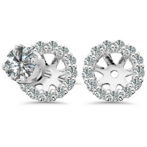May include: A pair of silver earrings with a halo of small diamonds around a center setting for a larger diamond. The earrings are designed to hold a larger diamond in the center.