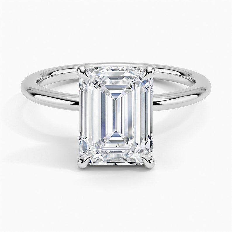 May include: A silver engagement ring with a large, clear emerald-cut diamond.