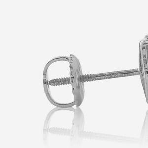 Peut inclure: Gros plan d'une boucle d'oreille argentée avec un fermoir à vis. La tige de la boucle d'oreille a un dos rond et texturé et une tige filetée. La tige se reflète sur la surface blanche en dessous. La boucle d'oreille est probablement en argent sterling ou en or blanc.