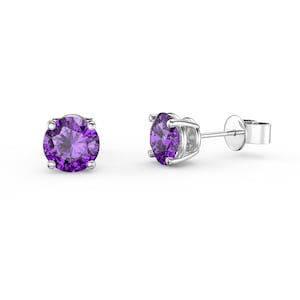 May include: A pair of silver stud earrings with a round, purple gemstone in each earring.