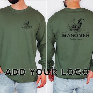 May include: Olive green long-sleeve shirt with a rooster graphic on the front and back. The back of the shirt features the text "ESTD 1970 MASONER Poultry Farms". The front of the shirt has the text "MASONER Poultry Farms".