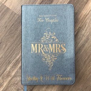 May include: Gray leather-bound journal with gold lettering that reads "366 Devotions For Couples" and "MR&MRS Shelby & Will Flowers".
