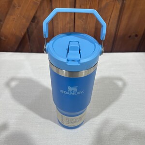 May include: A blue Stanley Flip Straw Tumbler with a handle. The tumbler has a stainless steel body and a blue lid with a flip straw.