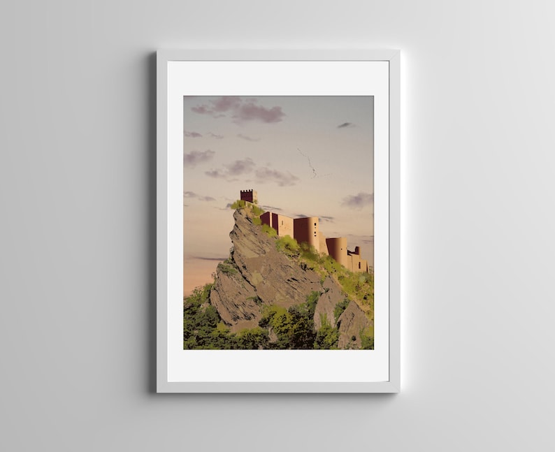May include: A framed art print featuring a digital illustration of a stone castle perched atop a jagged, rocky cliffside. The scene is set against a soft, pale sky with scattered clouds, with green foliage growing along the base of the mountain.