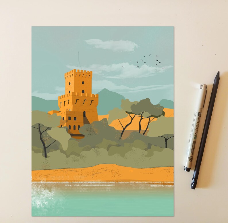 May include: A rectangular art print featuring a yellow stone tower with battlements, surrounded by green trees and mountains under a pale blue sky with birds. The print is positioned next to a white Micron pen and a black pencil on a light surface.