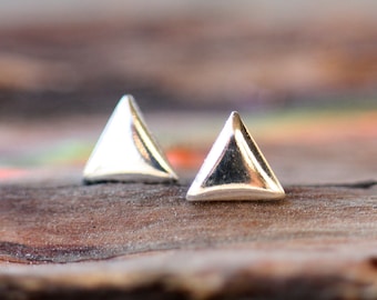 May include: A pair of silver triangle stud earrings. The earrings are small and simple, and they would make a great gift for a friend or loved one.