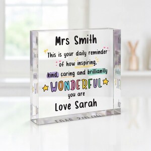 May include: A clear, rectangular acrylic block featuring the printed text: Mrs Smith, This is your daily reminder of how inspiring, kind, caring and brilliantly WONDERFUL you are, Love Sarah. The text includes colourful accents and star icons.