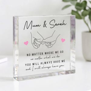 May include: A clear acrylic block with the text "Mum & Sarah" and a line drawing of two hands holding pinky fingers. Below the names is the text "NO MATTER WHERE WE GO...YOU WILL ALWAYS HAVE ME and I will always have you."