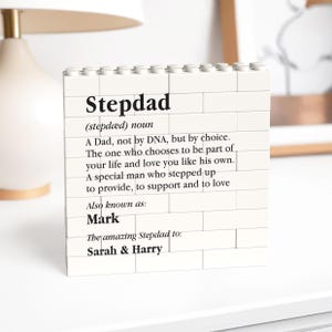 May include: A white brick-style block with the word "Stepdad" printed on it, along with a definition and the names "Mark", "Sarah & Harry". The block is a decorative item, possibly a gift.