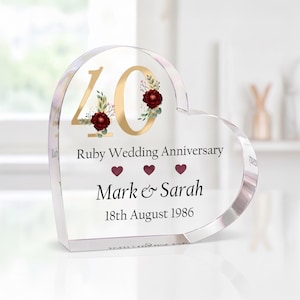 May include: A heart-shaped clear acrylic keepsake with gold-coloured "40" and the text "Ruby Wedding Anniversary" and names "Mark & Sarah" with the date "18th August 1986". The "40" is decorated with burgundy flowers.