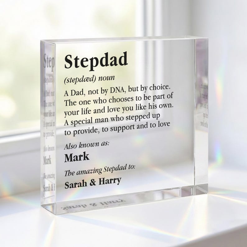 May include: A clear acrylic block with the word "Stepdad" and a definition printed on it. The definition describes a stepdad as a man who chooses to be a father figure. The block is personalized with the name "Mark" and the names "Sarah & Harry".