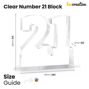 Puede incluir: Bloque transparente de acr&iacute;lico con el n&uacute;mero 21. El bloque mide 8,5 cm de alto, 8,5 cm de ancho y 1,2 cm de profundidad. El texto "Clear Number 21 Block" y "beecreative" est&aacute;n en la parte superior. Las palabras "Size Guide" est&aacute;n en la parte inferior.